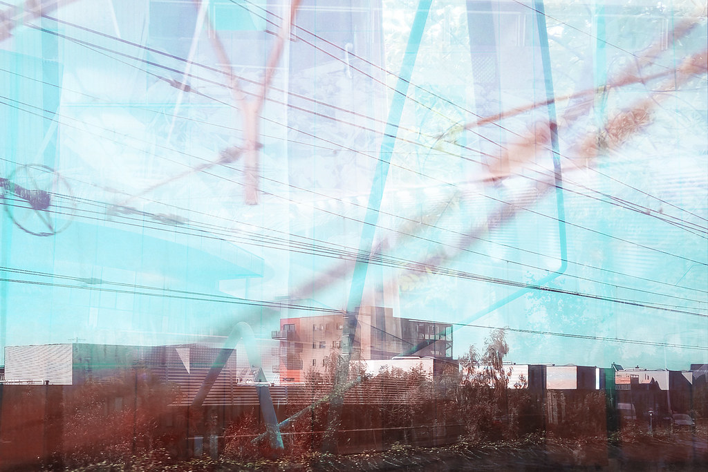 Multiple exposure of power lines and urban infrastructure, teal and red tones, Netherlands memory series