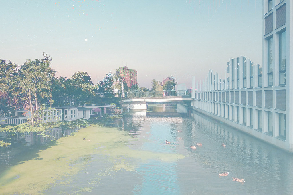 Double exposure of Amsterdam canal and modern bridge railing, soft light, digital collage"